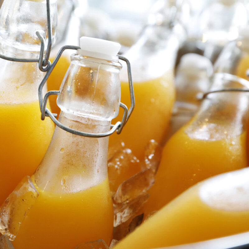 Closeup,Focus,Dept,Of,Field,Orange,Juice,Bottle,On,Ice