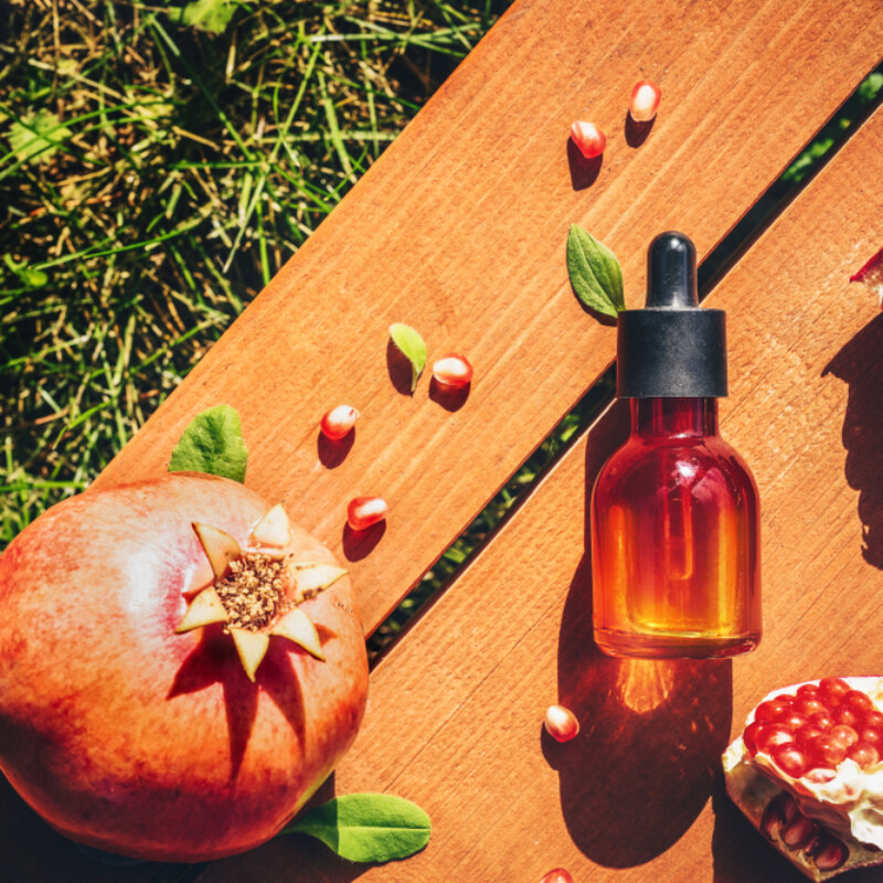 Pomegranate,Seed,Oil,,Serum,In,Glass,Bottle,On,Wooden,Background.
